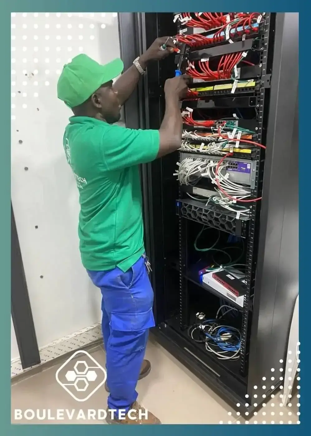 Technicien BoulevardTech brassant les câbles réseau d'une baie informatique à Bamako