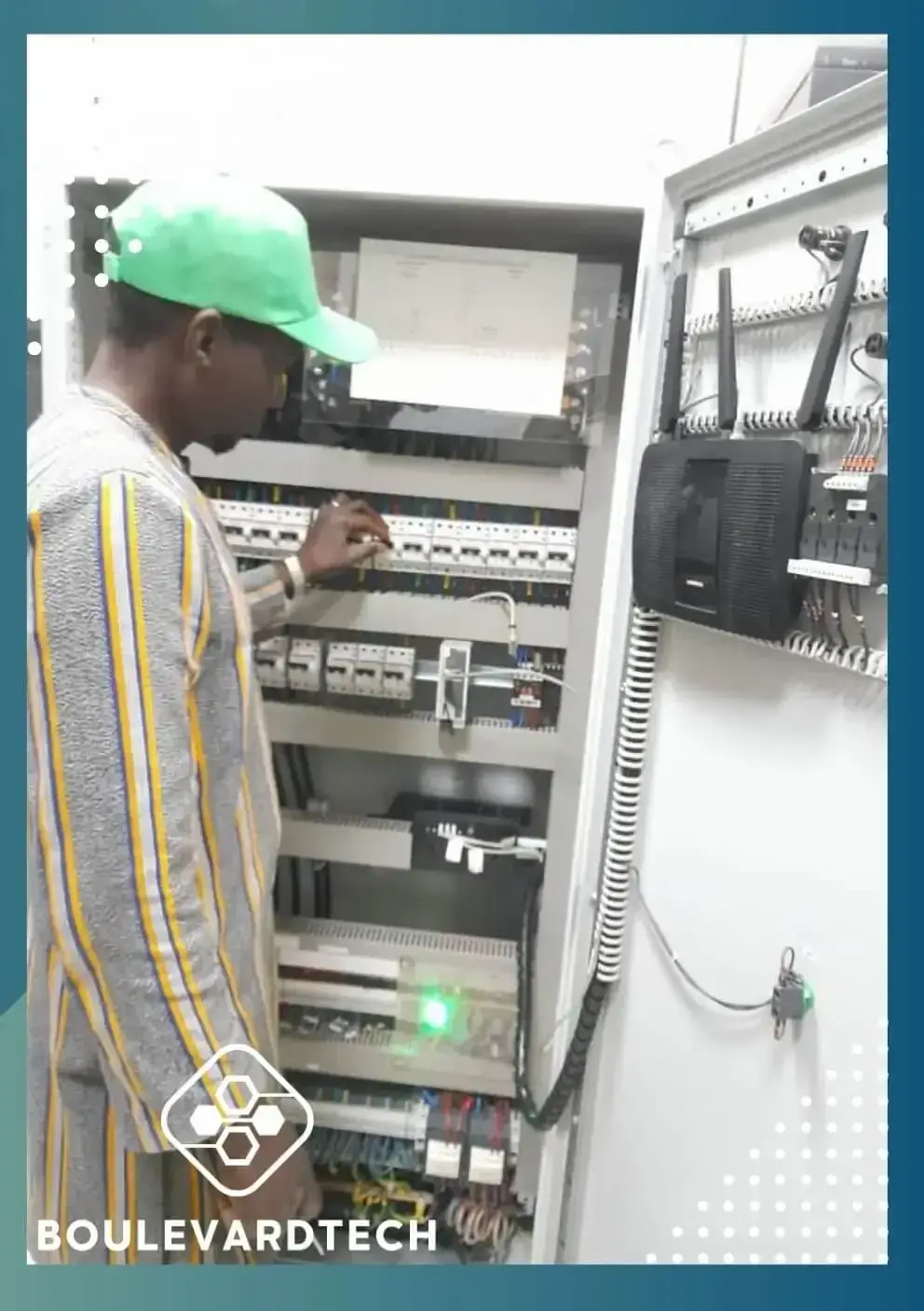 Technicien BoulevardTech contrôlant une armoire électrique et un point d'accès Wi-Fi au Mali
